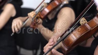 在交响音乐会上，两名女子在慢动作演奏木制小提琴
